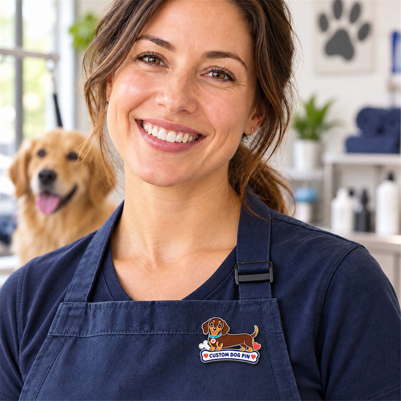 Woman wearing a dachshund enamel dog pin on a navy apron with a dog in the background