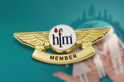Custom Pilot Wings Pin Gold Featuring Central 'hfm' and Red Drop Emblem With 'MEMBER' Text for Medical Charity Service Recognition