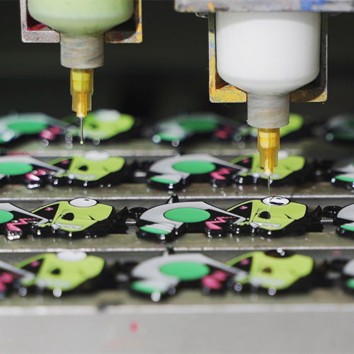 Advanced automated dispensing machine precisely color-filling custom metal pins in our factory, ensuring perfect consistency for soft enamel badges