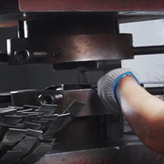 Heavy-duty hydraulic stamping machine using a custom metall mold to die-strike metal badge shapes with high pressure at the factory