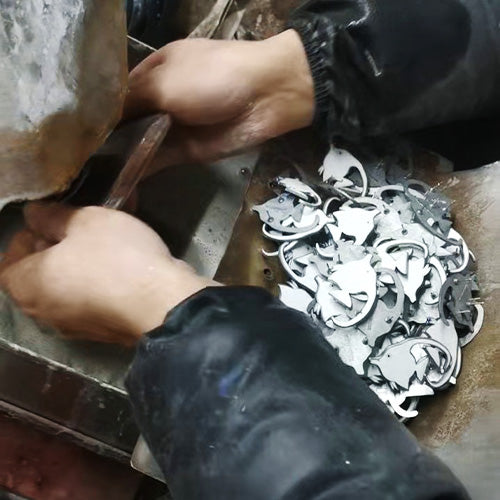 A worker at Yearpins factory performs final polishing on a custom hard enamel pin using a buffing wheel.