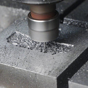 Advanced high-precision CNC engraving machine carving a detailed custom steel mold for metal badges, ensuring perfect replica of the custom design