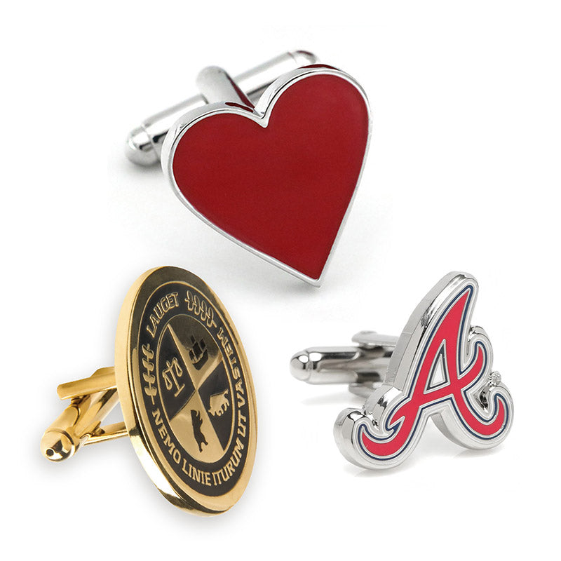 Display of custom cufflinks featuring three unique designs: heart-shaped in red and silver, oval in gold with black accents, and letter A in silver with red and blue, all showcasing examples of custom text.