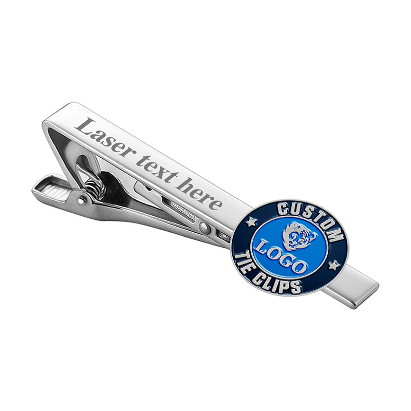 Custom silver tie clip with spring clip mechanism, featuring a laser text example area and a circular blue enamel emblem with space for custom logo and text.