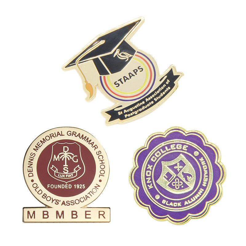 Custom School Pins Showcasing Three Distinct Academic Badge Designs: A Graduation Cap Shape With Colorful Rings, A Circular Red Brown Badge With School Crest, And A Purple Scalloped Circle With Shield Emblem, Featuring Custom Text For St Augustine Association, Dennis Memorial Grammar School, And Monk College Alumni Recognition