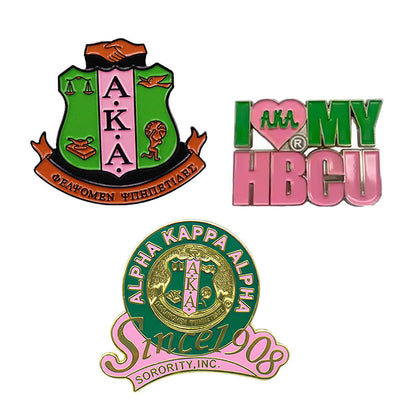 A collection of three custom Alpha Kappa Alpha pins, including an AKA crest design, 'I Love My HBCU' logo, and a 'Since 1908' anniversary pin.