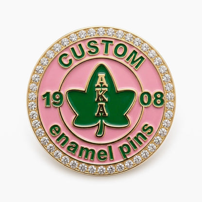 A custom round Alpha Kappa Alpha fraternity pin with a rhinestone border, featuring the AKA ivy leaf crest and 1908 founding year.