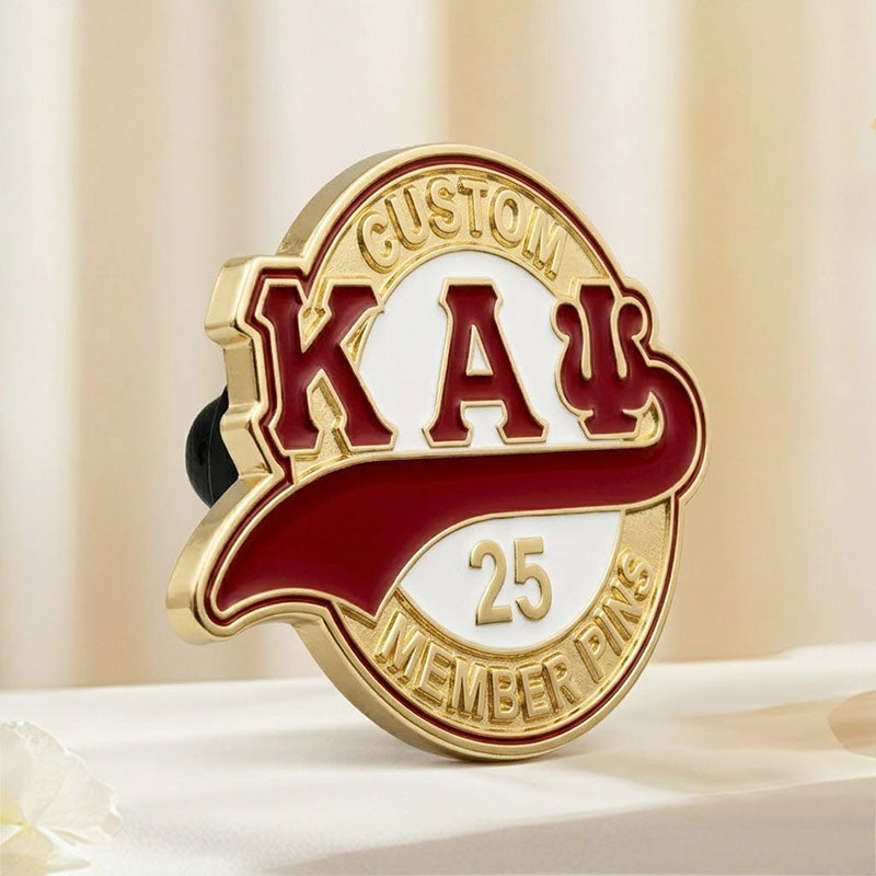 Side angle view of a custom gold-plated Kappa Alpha Psi fraternity pin, showcasing its metal edge on a soft cream background.