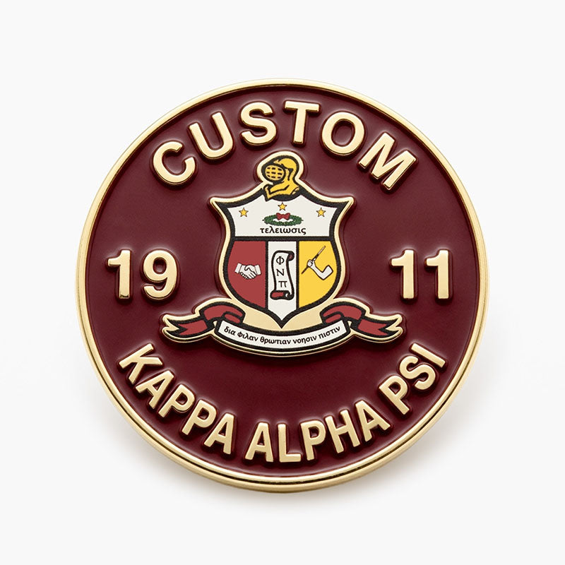 A custom gold KAP pin featuring the official Kappa Alpha Psi fraternity crest, flanked by the founding year 1911.