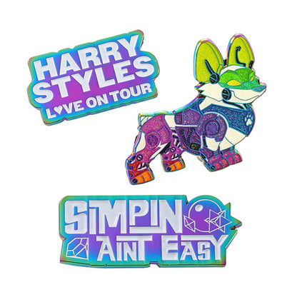 A collection of custom soft enamel badges with a Rainbow border including music tour merchandising and glitter cartoon shapes