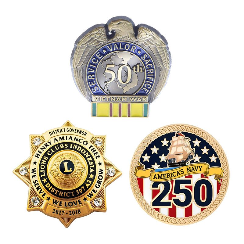 A display of three custom anniversary badges, featuring an eagle-topped Vietnam War 50th service pin, a gold-tone multi-pointed star Lions Clubs governor badge with rhinestone accents, and a round 250th commemorative America's Navy pin.