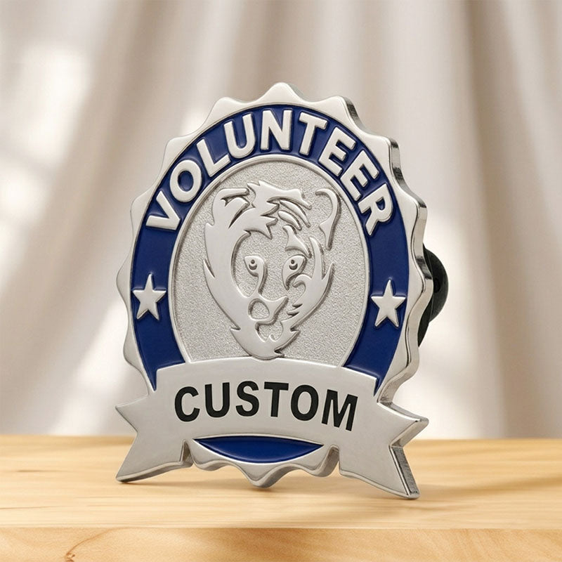 A side-angle perspective view of a custom volunteer service lapel pin in silver tone, displaying a textured silver center with a lion emblem, surrounded by a blue enamel border and a personalized bottom ribbon banner
