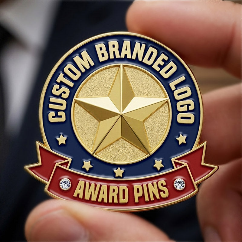 Gold tone award pin with 'Custom Branded Logo Award Pins' text held by a hand.
