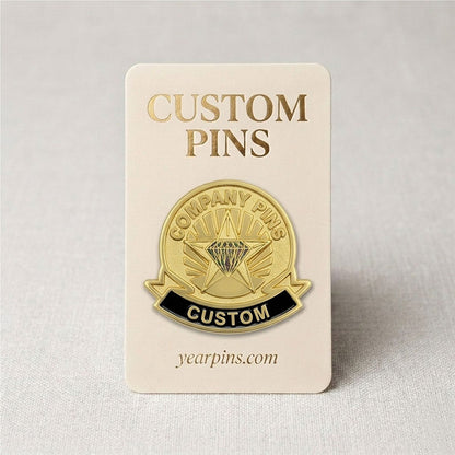 Custom gold tone company pin with a black enamel bottom ribbon displayed on a premium paper backing card for corporate gifts.