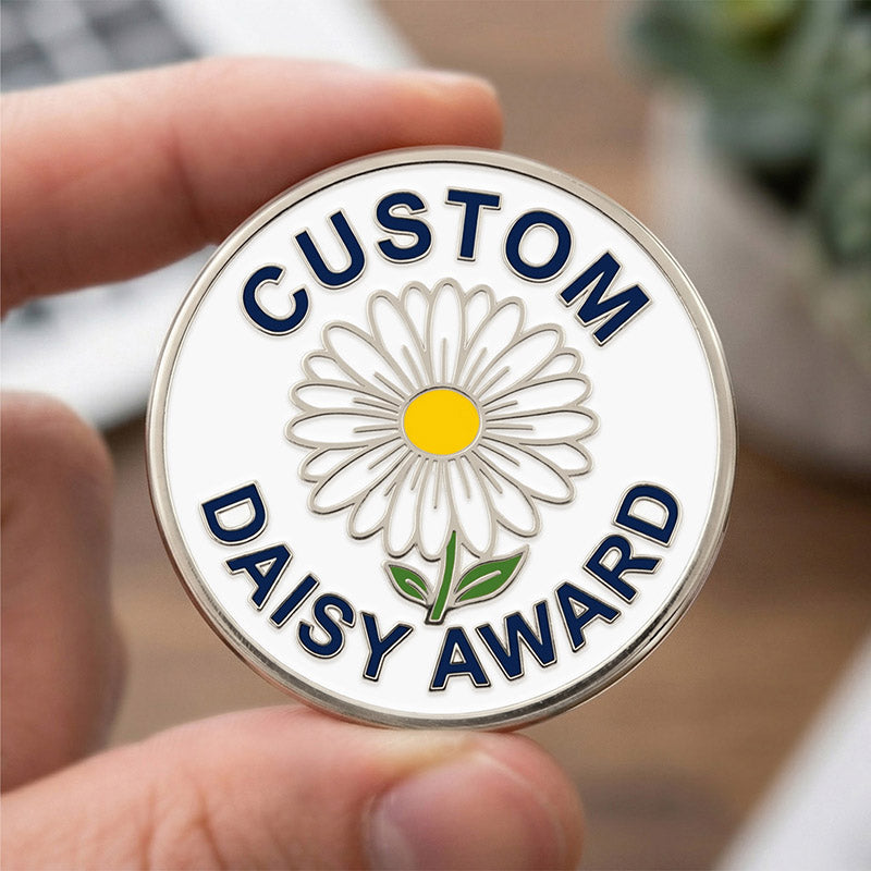 Custom Daisy Award coin held by a hand with a blurred background