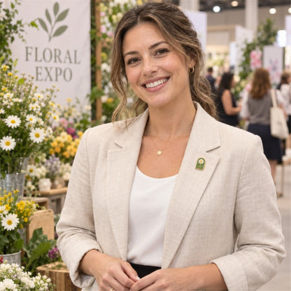 Woman wearing a green daisy lapel pin on a beige blazer at a floral expo