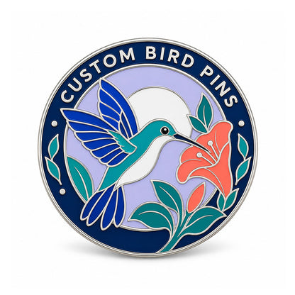 Round silver bird pin with a teal hummingbird beside a coral flower on lavender enamel