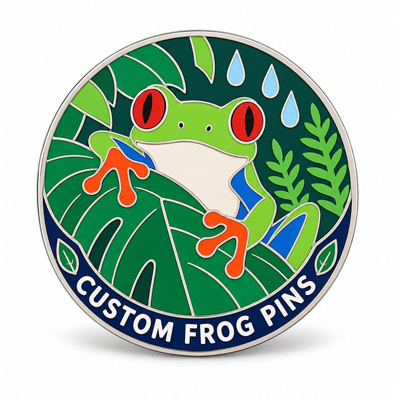 Round silver frog pin with a red-eyed tree frog, tropical leaves, and blue raindrops