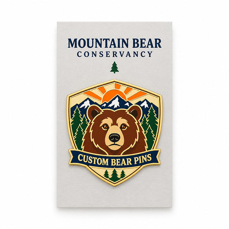 Brown bear enamel pin displayed on a cream Mountain Bear Conservancy backing card