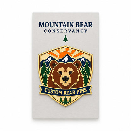 Brown bear enamel pin displayed on a cream Mountain Bear Conservancy backing card