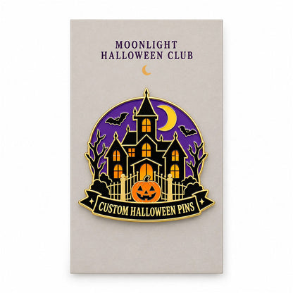 Haunted house enamel pin displayed on a Moonlight Halloween Club backing card