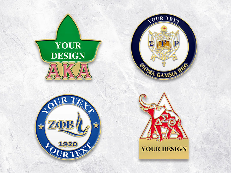 Sorority pins with Gold plating showcasing Alpha Kappa Alpha, Delta Sigma Theta, Zeta Phi Beta, and Sigma Gamma Rho designs on a marble background