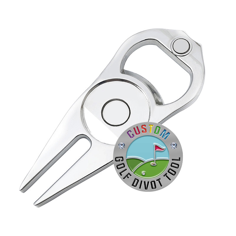 Silver multi-functional golf divot tool with integrated bottle opener and circular custom golf ball marker display featuring custom text, a red golf flag, white ball, and green background with small diamond accents