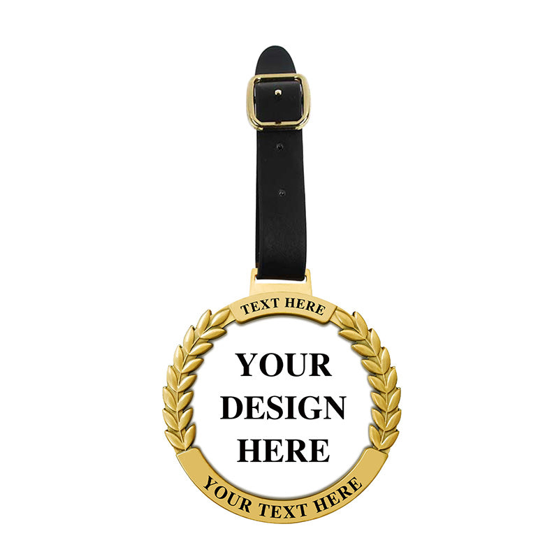 Gold personalized golf bag tag with a circular metal badge featuring custom text areas and a classic laurel wreath border design, connected to a black leather strap with a gold square clasp for easy attachment