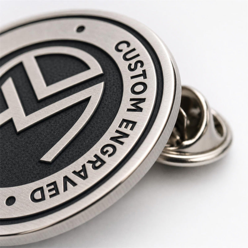 Close up of engraved pins showing recessed metal details, polished raised edges, and clean custom craftsmanship
