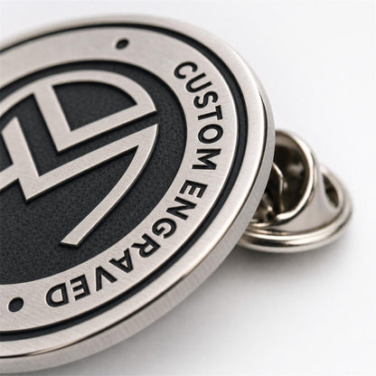 Close up of engraved pins showing recessed metal details, polished raised edges, and clean custom craftsmanship